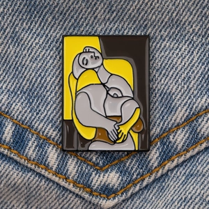 Gros plan d'une broche en émail artistique sur une poche de veste en denim