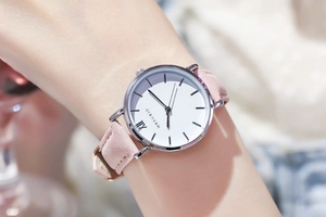 Nahaufnahme der minimalistischen Damenuhr mit rosa Lederband und römischen Ziffern