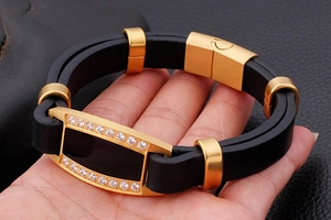 Detail of black leather and gold stainless steel men's bracelet with cubic zirconia stones