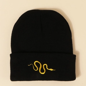Close-up detail of golden snake embroidery on a black ribbed knit beanie hat