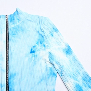 Détail de la texture côtelée tie-dye bleu et du zip noir sur ce body pour femme tendance