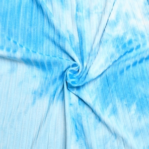 Gros plan sur le tissu en maille côtelée tie-dye bleu clair avec plis ondulés
