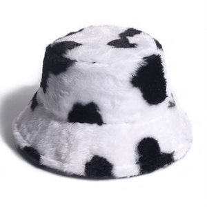 Detail of soft faux fur bucket hat featuring classic black and white cow print texture