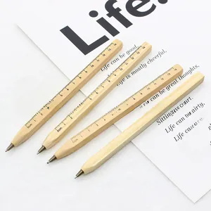 Close-up of wooden ballpoint pens with printed ruler scale on a minimalist desk background