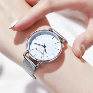 Minimalist silver women's watch with white dial and Milanese mesh band on a female wrist