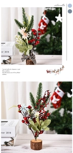 Close-up of mini artificial Christmas plant with red berries on a rustic wooden base