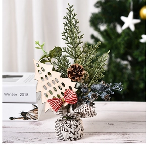 Detail of mini artificial Christmas tree with red berries, pine cones and burlap base