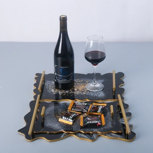 Detail of black agate resin tray set with gold leaf edges and metal handles