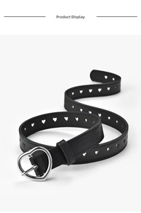 Detail showing black faux leather belt with heart-shaped cutouts and silver metal buckle