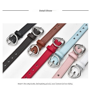 Close-up of stylish skinny belts with heart buckles and cutout holes in multiple colors