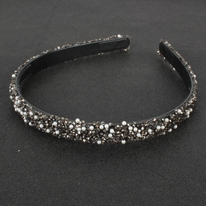 Detailed close-up of retro headband with white pearls and dark grey rhinestones