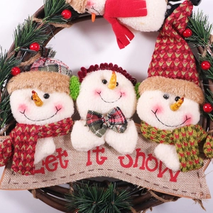 Christmas wreath with three plush snowmen and Let It Snow banner on brown rattan ring