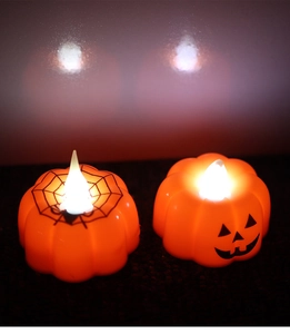 Detail of warm LED pumpkin candle lights with spider web and jack-o'-lantern patterns