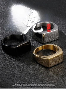 Macro detail of three punk style square signet rings in gold, silver, and black finishes