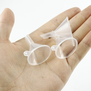 Close-up of three mini transparent plastic funnels held in hand showing small size scale