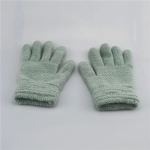 Close-up of light green knitted winter gloves for kids with ribbed elastic cuffs