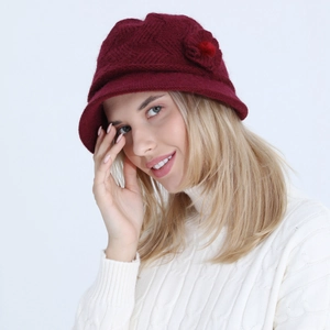 Detail of wine red knitted cloche hat with floral accent on a lifestyle model