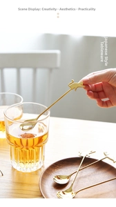 Detailed view of a gold cat-shaped stainless steel spoon hanging on a coffee cup