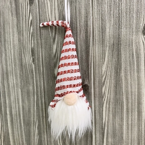 Close-up of a festive Christmas gnome ornament with red striped sequined hat and white beard