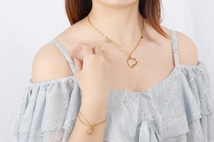 Close-up of heart pendant necklace and double-layer bracelet in gold stainless steel