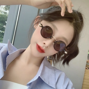 Close-up of retro steampunk round sunglasses with black lenses and slim metal temples
