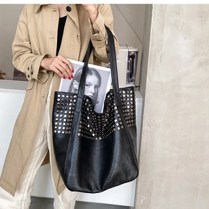 Close-up of stylish black studded tote bag showing large capacity for A4 magazines