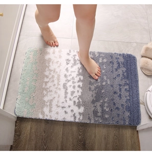 Close-up of fluffy absorbent bath mat with gradient color transition under bare feet