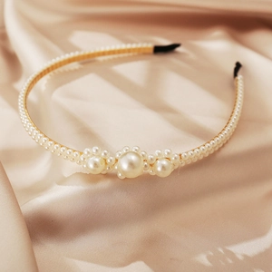 Elegant gold metal headband with white faux pearls on champagne silk background