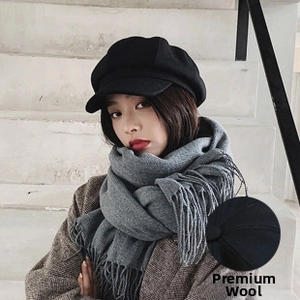 Detail of premium black woolen newsboy hat and thick grey tassel scarf set for winter