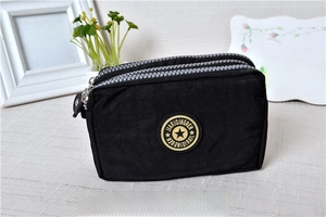 Close-up of black washed denim triple zipper pouch with star logo and compartments