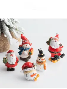 Detailed view of resin Santa and snowman figurines in a festive tabletop display