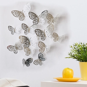 3D silver hollow butterfly wall stickers displayed on a wall for home decoration