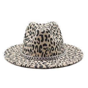 Détail du chapeau fedora à imprimé léopard avec une chaîne décorative en argent