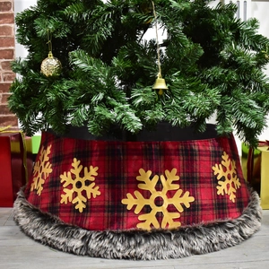 Detail of red and black plaid Christmas tree skirt with golden snowflake motifs