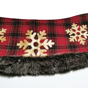 Close-up of red and black buffalo plaid Christmas tree skirt with golden snowflake detail