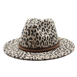 Close-up of leopard print fedora hat featuring cream base and brown woven hat band