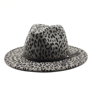 Close-up of leopard print fedora hat featuring black leather belt and gold buckle detail