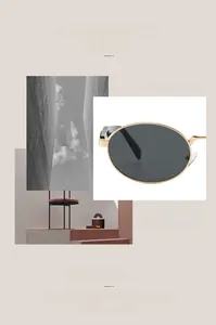 Detailed view of trendy oval sunglasses featuring sleek gold metal frames and dark lenses