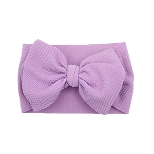 Detail view of lavender textured elastic fabric baby headband with a large bow design
