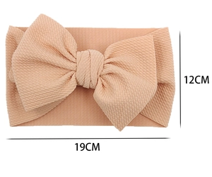 Detail view of light apricot baby headband with waffle texture and 19x12cm dimensions
