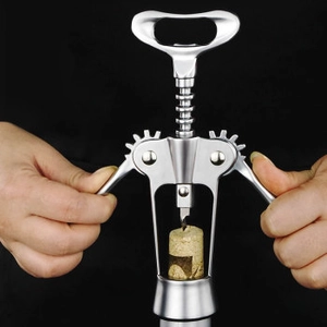 Close-up of a silver butterfly wine opener extracting a cork from a bottle neck