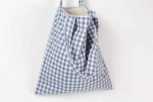 Detail of blue plaid cotton crossbody bag featuring a secure zipper and inner lining