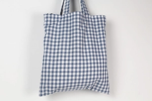 Detail of blue and white checkered cotton crossbody bag with durable woven handles