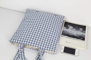 Detailed view of blue gingham cotton tote bag featuring soft fleece lining and metal zipper