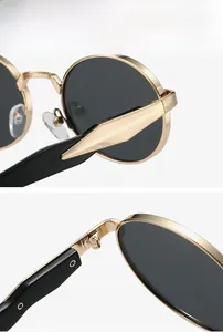 Detail of oval sunglasses featuring gold metal frame and durable hinge mechanism