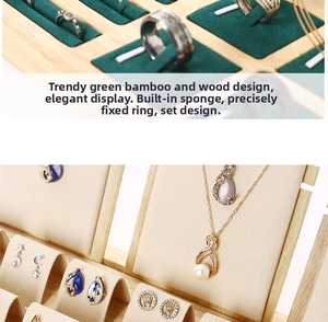 Detail of bamboo jewelry display stand with green ring slots and beige velvet necklace hooks
