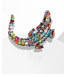Macro shot of crocodile brooch with colorful rhinestones on vintage silver alloy base