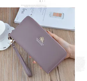 Close-up of litchi texture women's long wallet in dusty rose with clover metal buckle
