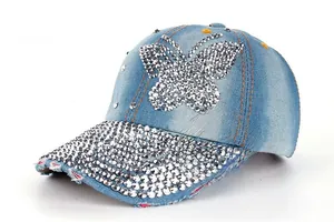 Close-up of light blue denim baseball cap with rhinestone butterfly and frayed brim details