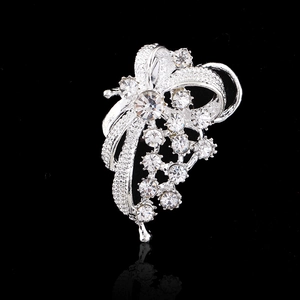 Elegant silver flower brooch with sparkling rhinestones shown on a reflective black background